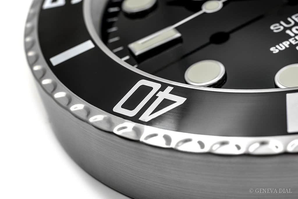 Nahaufnahme der gebürsteten Lünette aus AISI 304L-Stahl und des gewölbten Mineralglases mit 2.5x-Zykloplupe von GENEVA DIAL